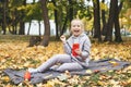 Gen z teenage girl using smartphote outdoors in autumn time.