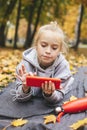 Gen z teenage girl using smartphote outdoors in autumn time.