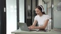 Gen Z young student girl in headphones studying internet at laptop Listen to audio narration Webinars Writing notes,