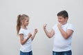 Gender issues concept of two caucasian sport healthy kids little thick strong boy against small thin weak girl holding fist ready Royalty Free Stock Photo