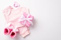Top view photo of infant clothes pink shirt pants knitted booties giftbox with ribbon bow and soother Royalty Free Stock Photo