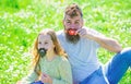 Gender roles concept. Family spend leisure outdoors. Dad and daughter sits on grassplot, grass on background. Father