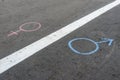 Gender symbol of a man and a woman drawn in chalk on the asphalt