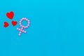 Gender Venus symbol made of contraceptive pills, near heart sign - woman health concept - on blue background top-down