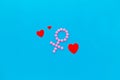 Gender Venus symbol made of contraceptive pills, near heart sign - woman health concept - on blue background top-down