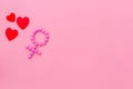 Gender Venus symbol made of contraceptive pills, near heart sign - woman health concept - on pink background top-down
