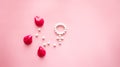 Gender Venus symbol made of pills, and peony flower petals on a pink background.