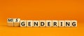 Gendering or misgendering symbol. Concept words Gendering Misgendering on wooden blocks. Beautiful orange table orange background