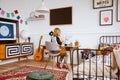 Genderless bedroom with kid painting at the retro desk in tenement house