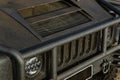 A closeup front view of an AM General Humvee in matte black - headlights, hummer grill