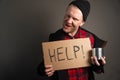 The general plan of the homeless man holding a cardboard with the inscription in his hands asks for help. begging concept Royalty Free Stock Photo