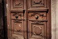 Very old antique looking wooden doors opening to the street, under the sun light, browny, closeup view. Royalty Free Stock Photo