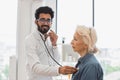 General practitioner, looking at camera, examining heartbeat while in clinic. Royalty Free Stock Photo