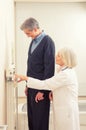 General practitioner measuring male patient's height in hospital