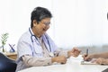 General practitioner taking notes when talking to female patient in hospital. Royalty Free Stock Photo