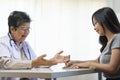 General practitioner taking notes when talking to female patient in hospital. Royalty Free Stock Photo