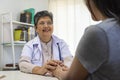 General practitioner taking notes when talking to female patient in hospital. Royalty Free Stock Photo