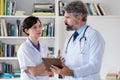 General practitioner talking with nurse about therapy of patient Royalty Free Stock Photo