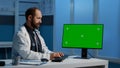 General practitioner typing medical expertise on computer with greenscreen chroma key template Royalty Free Stock Photo