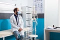 General practitioner with white coat sitting on bed in checkup cabinet Royalty Free Stock Photo