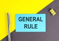 GENERAL RULE text written on sticky with pen on grey, yellow background, business concept