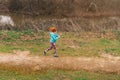 General shot of a sporty red-haired Caucasian female running while checking her surpluses outdoor Royalty Free Stock Photo