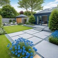 general view of back garden with artificial grey paving slab flower bed with