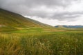 General view of the valley, Castelluccio di Norcia, in Umbria, Italy. Fields and hills, with red poppies in foreground. Royalty Free Stock Photo