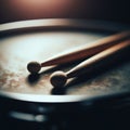 Drumsticks rest on a snare drum, in atmospheric light