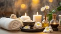 Atmospheric spa backdrop with candles, plumeria, bowl of salt, oil, massage stones and towels on light background Royalty Free Stock Photo