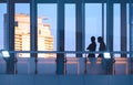 Silhouette of 2 female tourists walking on the elevated glass walkway of modern building in sunset time Royalty Free Stock Photo