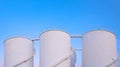 Group of white storage fuel tanks in oil industrial area against blue sky background Royalty Free Stock Photo