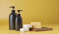 Bottles of shampoo and soap bars on yellow background with copy space Royalty Free Stock Photo