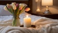 Burning candle and vase with tulips on bed, closeup Royalty Free Stock Photo