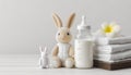 Feeding bottle with milk, diapers and toy bunny on white background with copy space