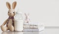 Feeding bottle with milk, diapers and toy bunny on white background with copy space