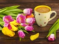 Spring bouquet of yellow and pink tulips and a white polka dot cup of coffee on a dark wooden background.ted image Royalty Free Stock Photo