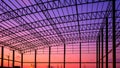 Silhouette industrial building structure with curved roof beam and column in construction site against colorful twilight sky