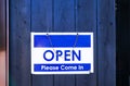 Blue and white plastic sign or symbol letter Open Please come Attached to the blue wooden door is background Royalty Free Stock Photo