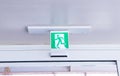 Fire exit green emergency exit signs hanging on ceiling, exit door. Warning plate with running man icon. Royalty Free Stock Photo