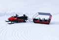 Red Snowmobile ski-doo with truck trailer. Skidoos parking in snow-white yard. Royalty Free Stock Photo