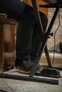 Image of a man\'s foot using the sustain pedal on the piano keyboard while playing music.