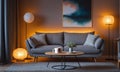 Interior of living room with cozy grey sofa, armchair and glowing lamps Royalty Free Stock Photo