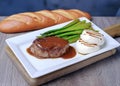 A freshly cooked juicy steak and roasted mozzarella lies on a white dishes