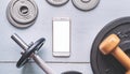 A smartphone with white screen and weightlifting on metal background Royalty Free Stock Photo