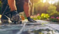 Close up on the hands and tools of an expert workman laying patio slabs in garden makeover. Created with AI Royalty Free Stock Photo