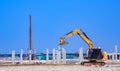 Excavator with pile driver machine are installing many precast concrete piles on the ground in factory construction site Royalty Free Stock Photo