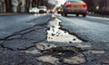Close up of a pothole on a busy city street Royalty Free Stock Photo
