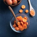 Dicing carrots in a glass bowl, top view. Carrots with knife and wooden spoon Royalty Free Stock Photo
