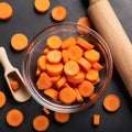 Dicing carrots in a glass bowl, top view. Carrots with knife and wooden spoon Royalty Free Stock Photo